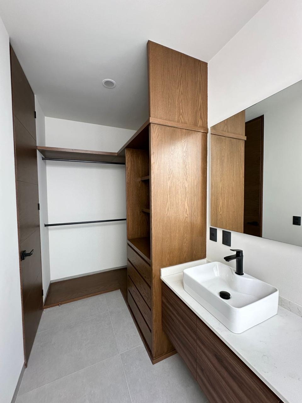 Cubierta de baño en piedra blanca con lavabo sobre mueble de madera